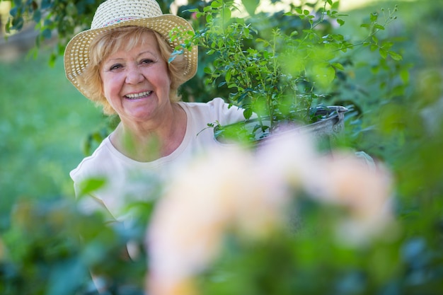 Senior mujer de pie en el jardín