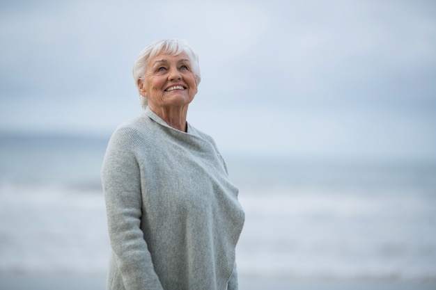 Senior mujer de pie en la playa