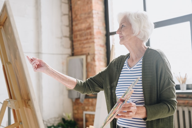 Senior mujer pintando en Art Studio