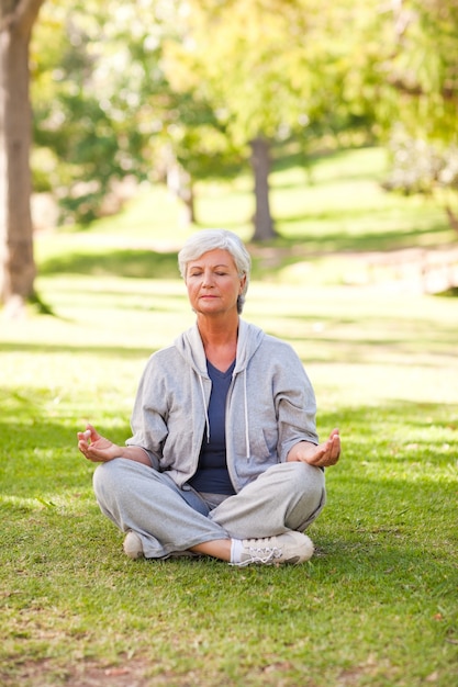 Senior mujer practicando yoga en el parque