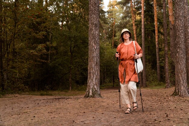 Senior mujer sana activa a pie en el bosque