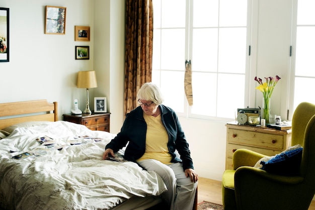 Senior mujer sentada en la cama