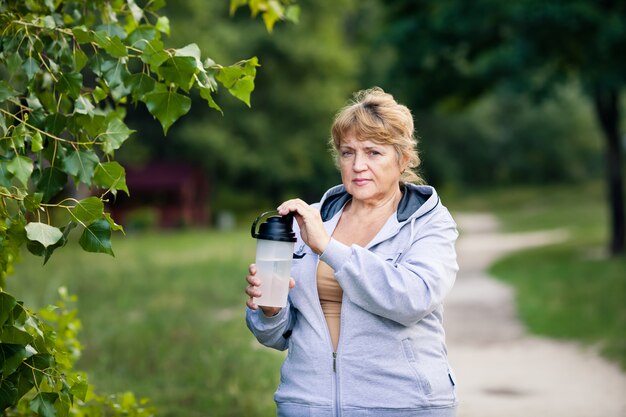 Senior mujer sosteniendo una botella de agua