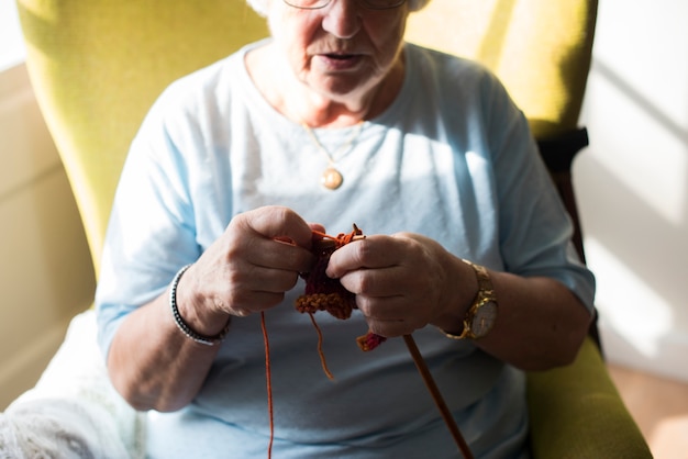 Senior mujer tejiendo por hobby en casa