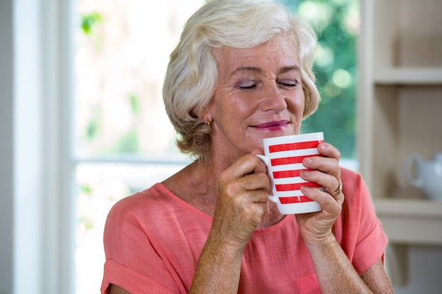 Senior mujer tomando un café en casa