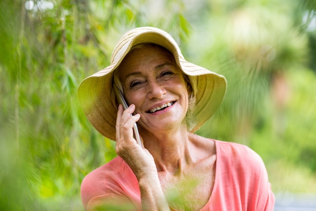 Sênior mulher falando no telefone no quintal