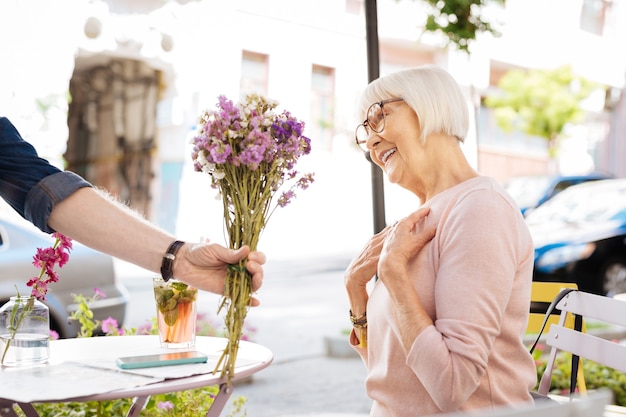 sênior oferecendo flores para a esposa