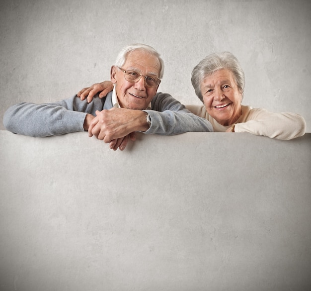 Foto senior par sostener con un tablero en blanco