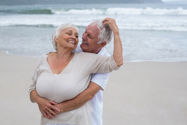 Senior pareja abrazándose en la playa