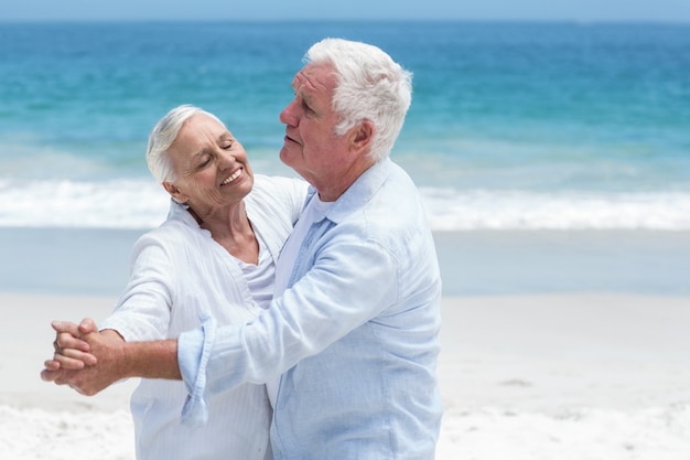 Senior pareja bailando en la playa