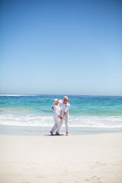 Senior pareja bailando en la playa