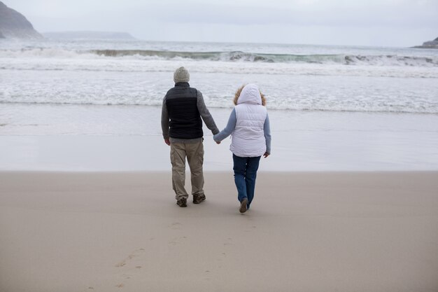 Senior pareja caminando juntos en la playa