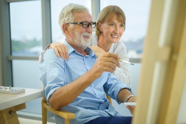 Senior pareja caucásica pintando y relajándose en casa