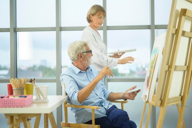 Senior pareja caucásica pintando y relajándose en casa