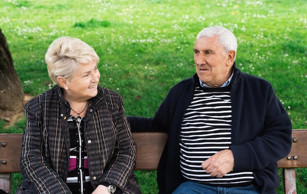 Senior pareja charlando mientras está sentado en un banco del parque Anciano esposo y esposa disfrutando de la jubilación