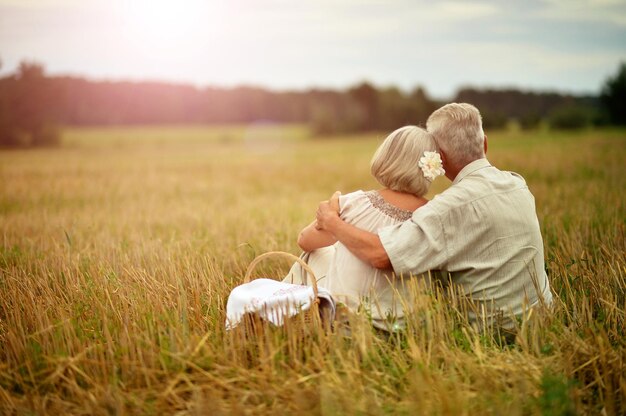 Senior pareja descansando en el campo de verano