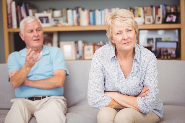 Senior pareja discutiendo mientras está sentado en el sofá