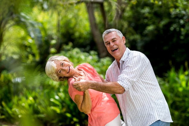 Senior pareja disfrutando mientras baila en el patio