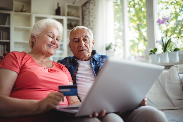 Senior pareja haciendo compras en línea en la computadora portátil