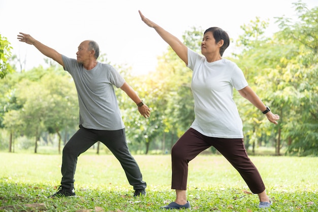 Senior pareja haciendo ejercicios de estiramiento en el parque.