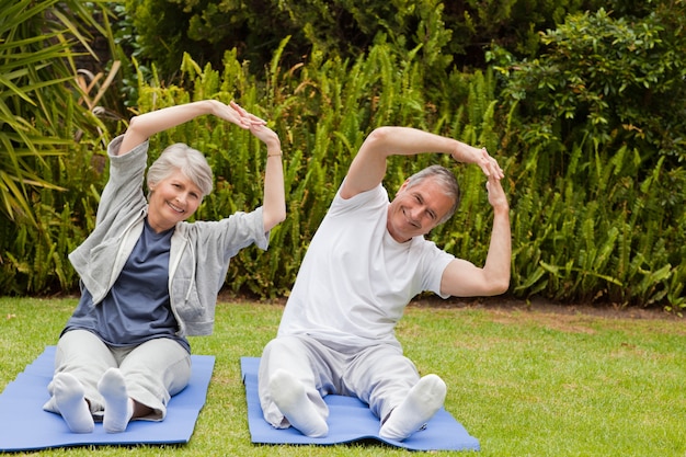 Senior pareja haciendo sus streches en el jardín