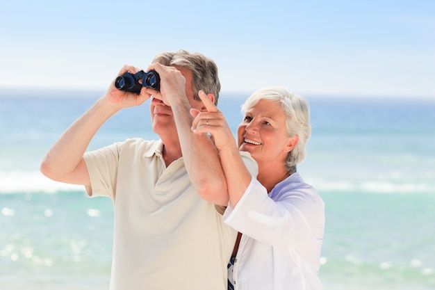 Senior pareja de observación de aves en la playa