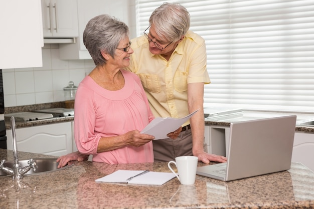 Senior pareja pagando sus cuentas con la computadora portátil