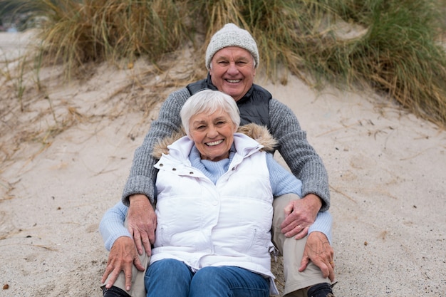 Senior pareja sentados juntos en la playa