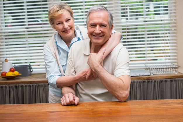 Senior pareja sonriendo a la cámara junto