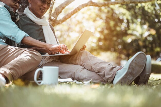 Senior, parejas, jubilación, seguros, ancianos, concepto de estilo de vida. Las parejas mayores sentadas y hablando en el césped al aire libre por la mañana sobre planes de seguro de vida con un concepto de jubilación feliz.