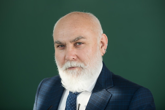 Senior-Professor, Nahaufnahmeporträt eines denkenden Lehrers mit grauem Haar an der Tafel