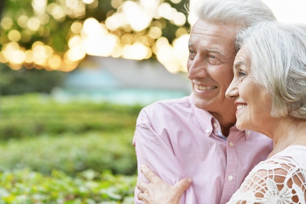 Senior sonriente pareja abrazándose en el parque de otoño