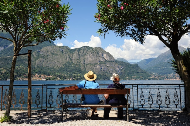 Sênior turistas sentado admirando um lago de montanha