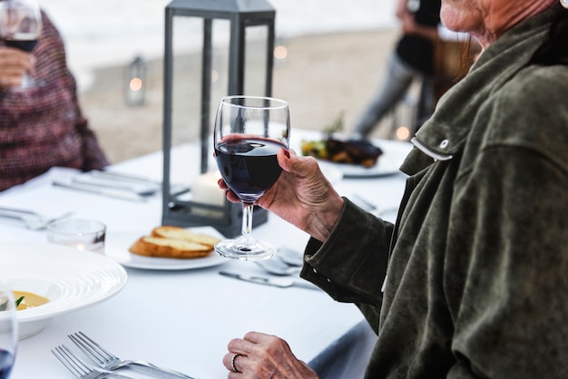 Senioren, die mit Rotwein am Strand rösten