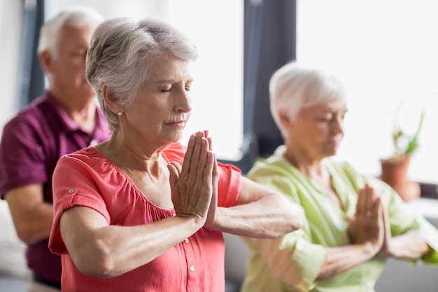 Senioren, die Yoga mit geschlossenen Augen tun