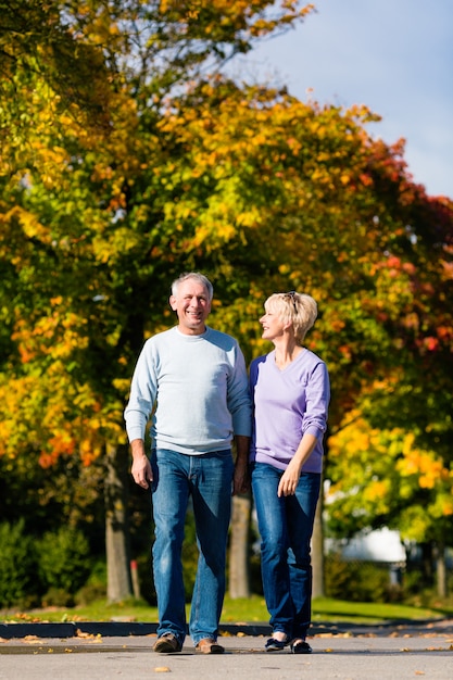 Senioren im Herbst oder Herbst gehen Hand in Hand