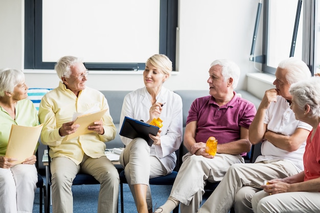 Senioren und Krankenschwester halten Dokumente