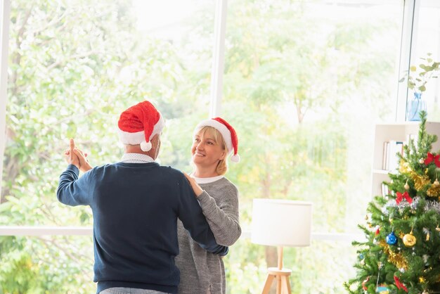 Seniorenpaar tanzt am Weihnachtstag und ist glücklich