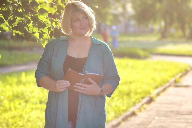 Seniorin im Park mit Buch