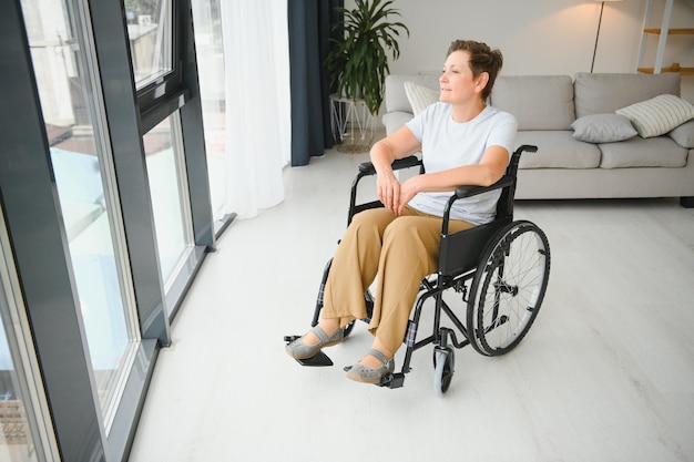 Seniorin im Rollstuhl zu Hause im Wohnzimmer