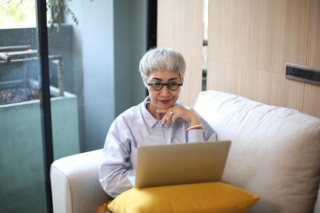 Seniorin mit Laptop im Zimmer