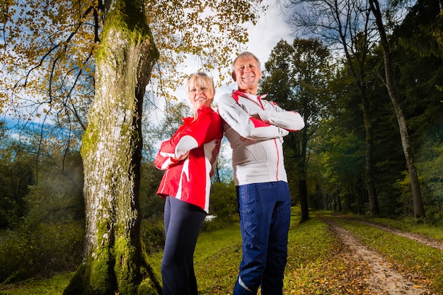 Seniors entrenamiento deportivo en un camino forestal