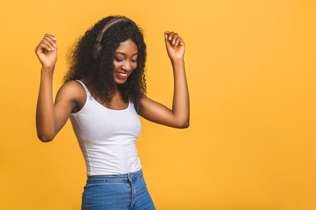 Señora afroamericana inspirada escuchando música, bailando con los ojos cerrados