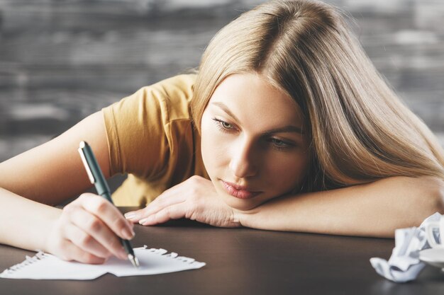 Foto señora agotada escribiendo en papel