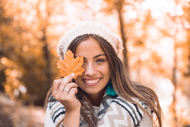 Foto señora alegre con hoja de otoño