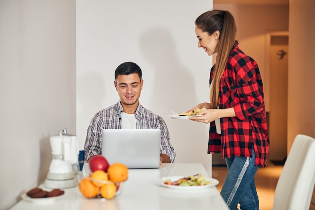 Señora alegre que sirve la tortilla a su marido