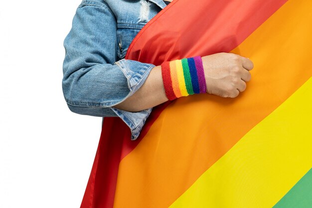 Señora asiática con chaqueta de jean azul con bandera de color del arco iris, símbolo del mes de orgullo LGBT.