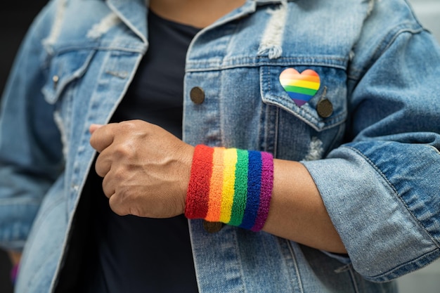 Foto señora asiática con pulseras de la bandera del arco iris, símbolo del mes del orgullo lgbt, celebra anualmente en junio social de derechos humanos gay, lesbiana, bisexual y transgénero