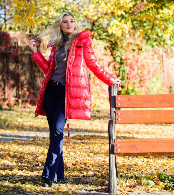 Señora atractiva fashionista posando en chaqueta Chaqueta para el concepto de temporada de otoño Mujer rubia de moda con puesto de maquillaje en el parque otoñal Chica usa chaqueta roja brillante y cálida Concepto de moda de otoño