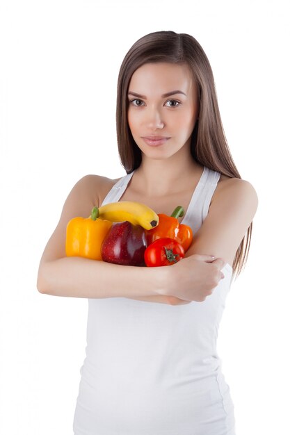 Señora atractiva sana joven que sostiene las vitaminas en sus manos Mujer con frutas y verduras studio shot.